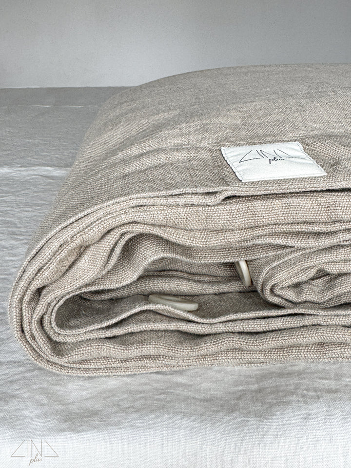 LINOTELA linen duvet cover, folded and rolled with label detail
