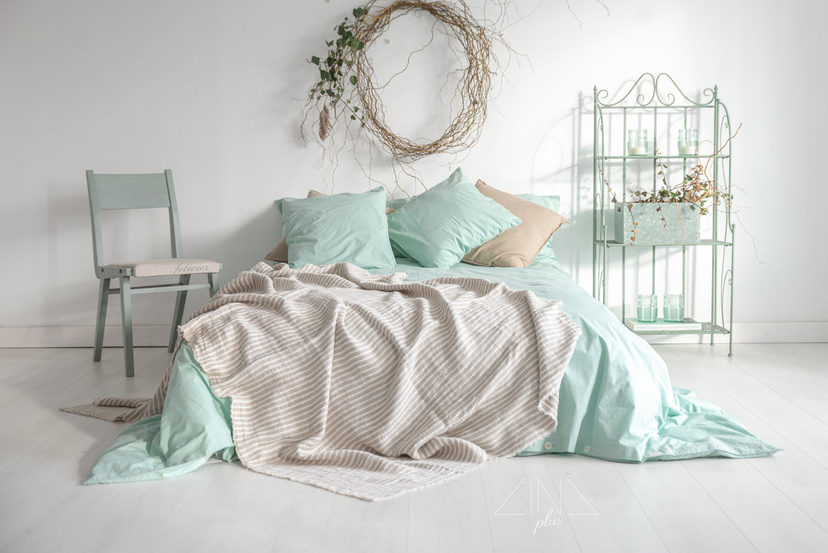 SIMPLIN Twill Linen Throw in STRIPES draped across bed with green pillows