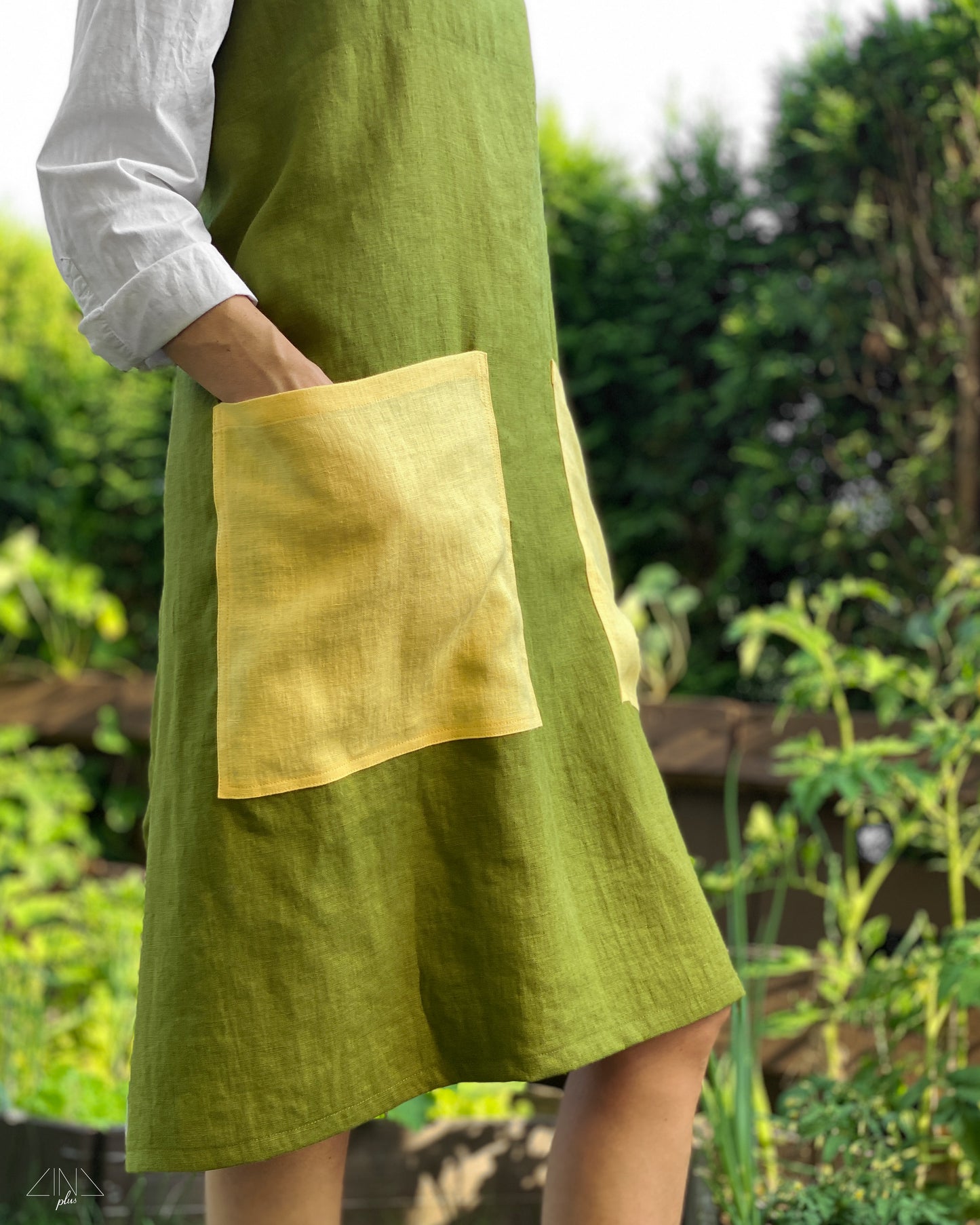 Bicolor Linen Pinafore Apron in Moss Green with Yellow Pockets and Straps for gardening.